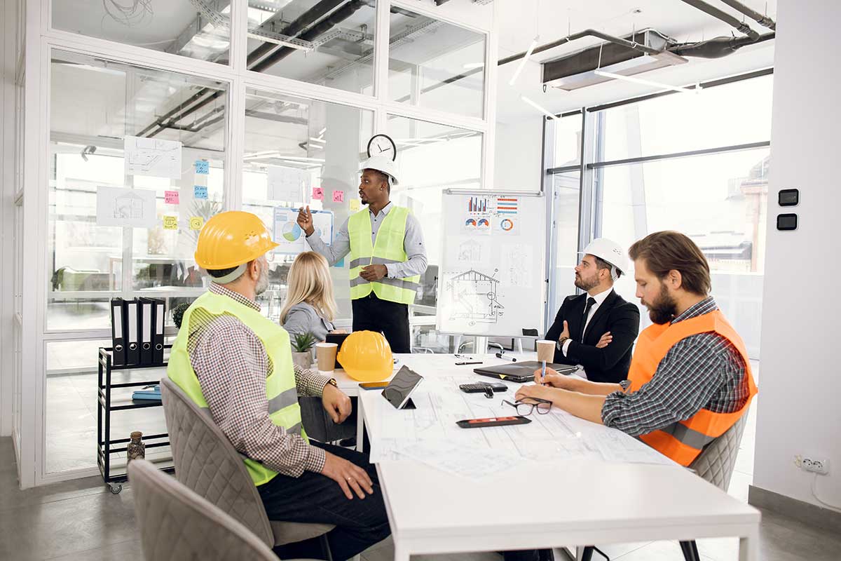picture of an over the shoulder shot of an architect or engineer looking at the blue prints of a cylindrical build. he has a pencil in his hand and is editing the drawing and double checking the blue print. He hopefully has professional indemnity in case a build he has signed off on, is actually not sound or if he made a mistake in the measurements. 