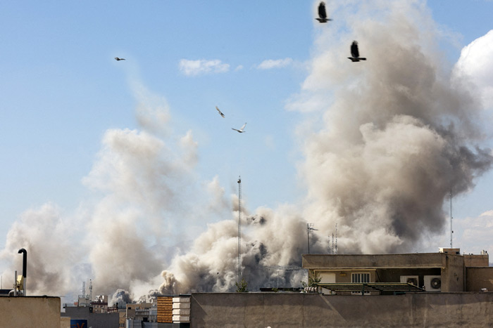 Thick smoke rising over rooftops in a built up urban area during civil unrest